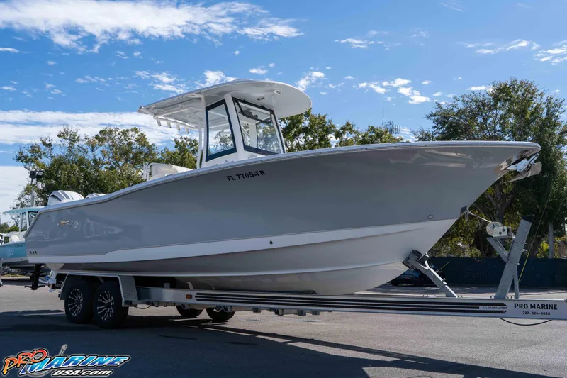 Slide: The Image of 2024 Sea Hunt Gamefish 27 boat on trailer under clear blue sky. - 3