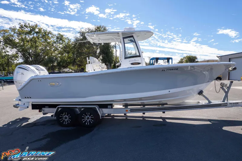 Slide: The Image of 2024 Sea Hunt Gamefish 27 boat on trailer, parked outdoors under a clear sky. - 30
