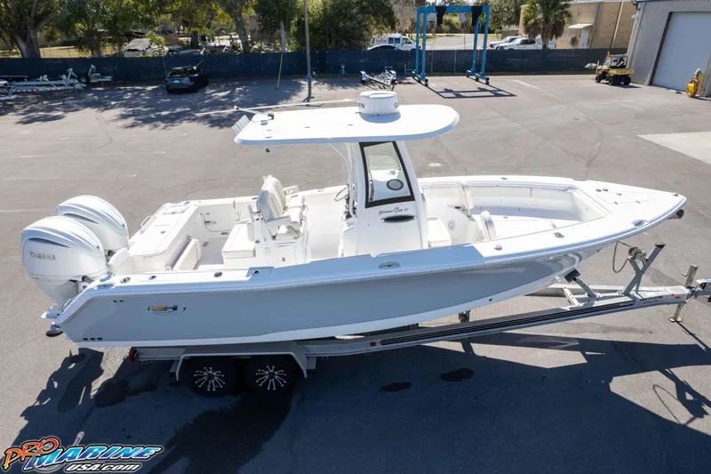 Slide: The Image of 2024 Sea Hunt Gamefish 27 boat on trailer, featuring dual Yamaha engines. - 34