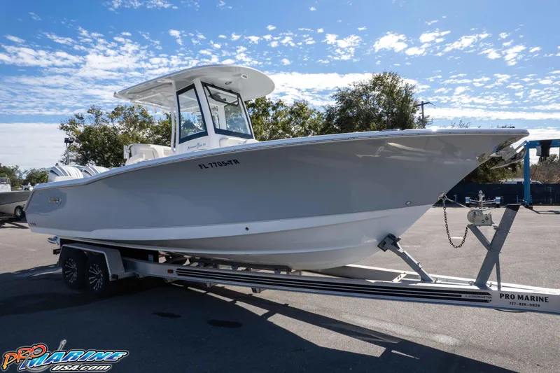 Slide: The Image of 2024 Sea Hunt Gamefish 27 boat on trailer under clear sky. - 36