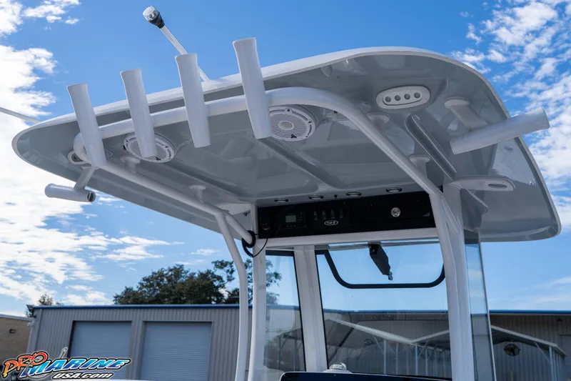 Slide: The Image of 2024 Sea Hunt Gamefish 27 boat with T-top and rod holders under a blue sky. - 45