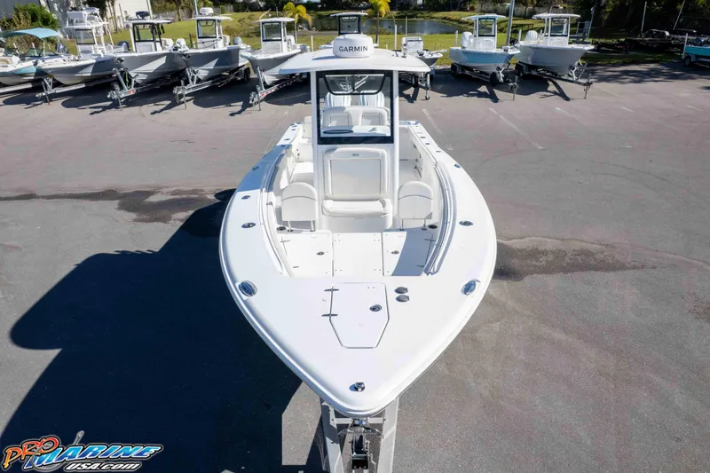 Slide: The Image of 2024 Sea Hunt Gamefish 27 boat displayed in a marina, showcasing sleek design and spacious deck. - 46