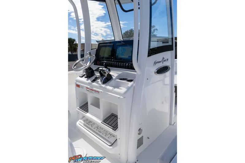 Slide: The Image of 2024 Sea Hunt Gamefish 27 boat console with steering wheel and controls. - 49
