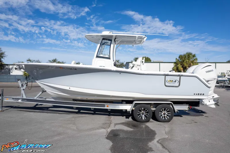 Slide: The Image of 2024 Sea Hunt Gamefish 27 boat on trailer, side view, clear sky background. - 6