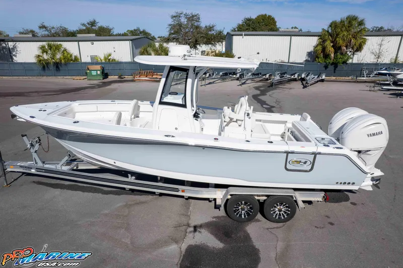 Slide: The Image of 2024 Sea Hunt Gamefish 27 boat on trailer, featuring Yamaha engines. - 8