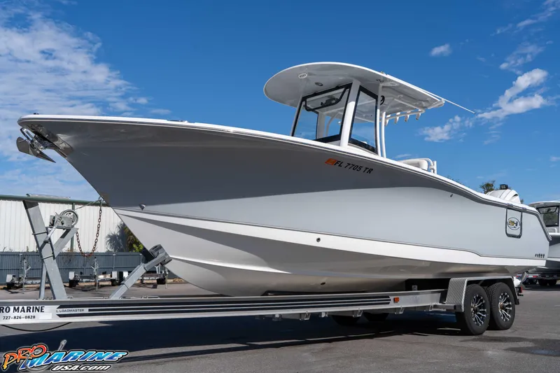 Slide: The Image of 2024 Sea Hunt Gamefish 27 boat on trailer under clear blue sky. - 9