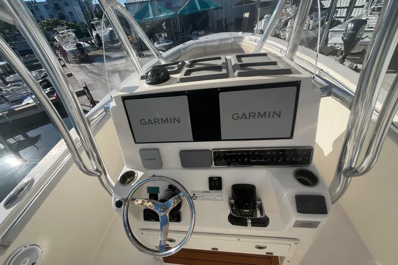 Slide: The Image of 2017 Cobia 277 Center Console boat dashboard with dual Garmin displays and steering wheel. - 11