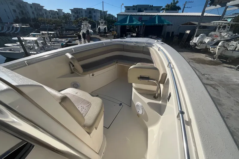 Slide: The Image of 2017 Cobia 277 Center Console boat interior at marina, showcasing seating and deck layout. - 12