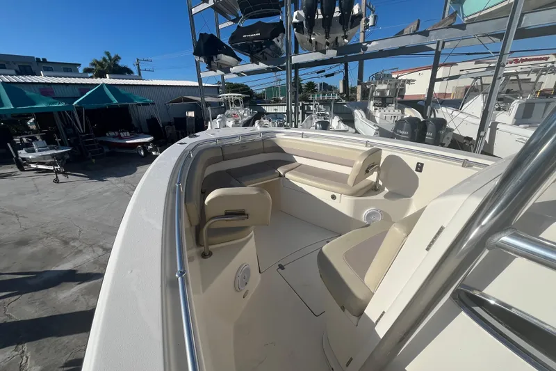 Slide: The Image of 2017 Cobia 277 Center Console boat with seating, docked in a marina under clear blue skies. - 13