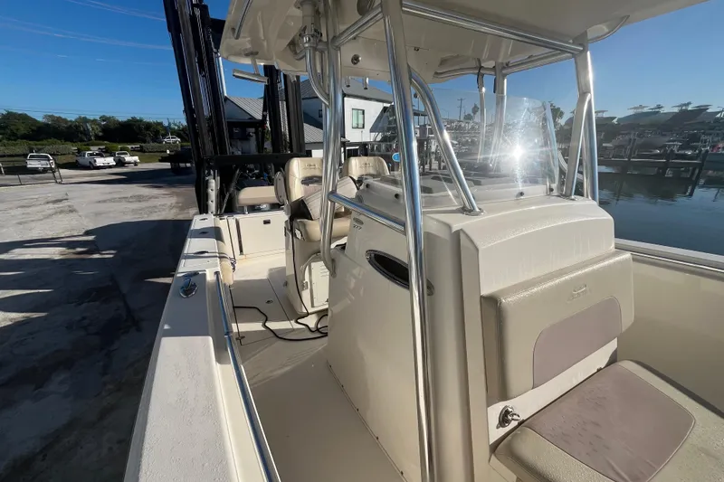 Slide: The Image of 2017 Cobia 277 Center Console boat docked, showcasing helm and seating area. - 15