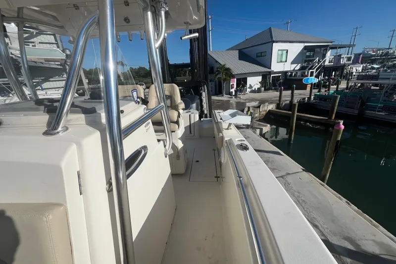 Slide: The Image of 2017 Cobia 277 Center Console boat docked at a marina. - 16