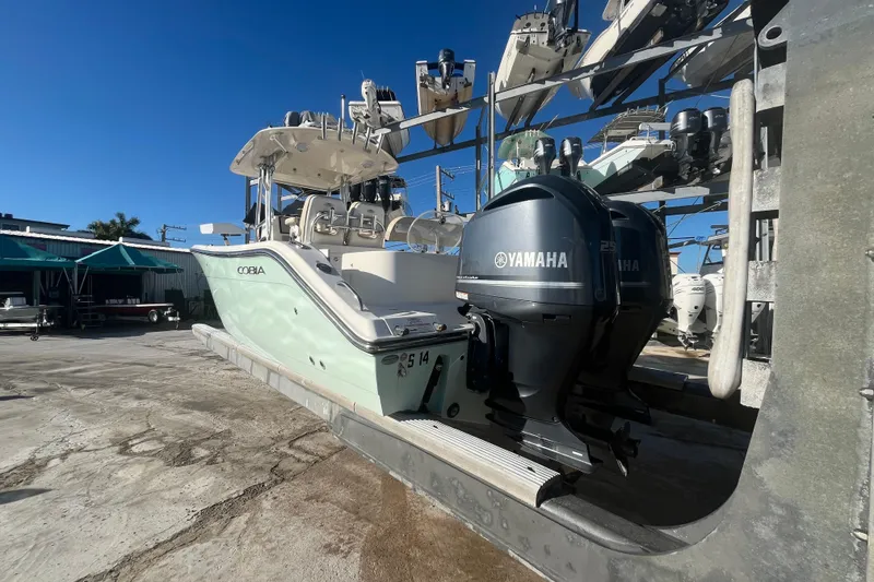 Slide: The Image of 2017 Cobia 277 Center Console boat with Yamaha engines on a dock. - 6