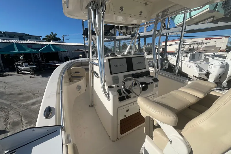 Slide: The Image of 2017 Cobia 277 Center Console boat with dual Garmin displays and beige seating. - 9