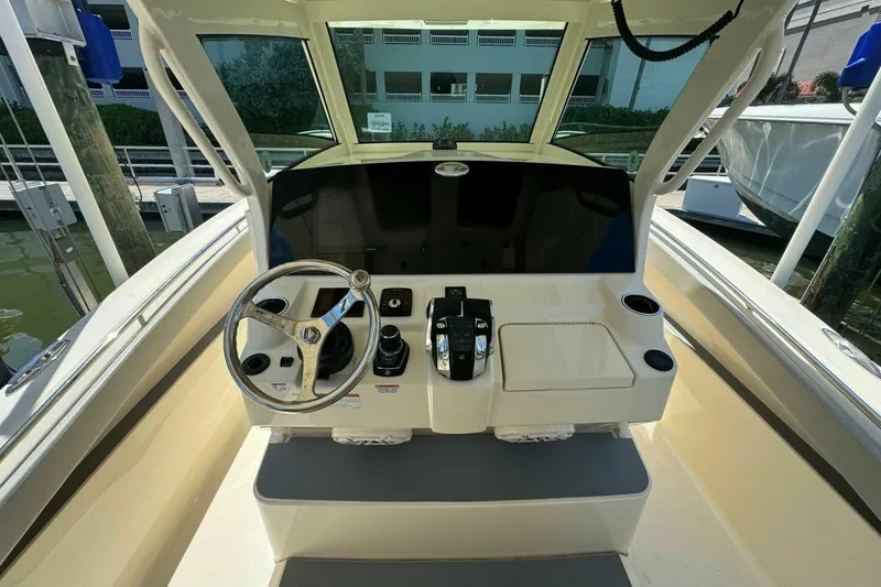 Slide: The Image of 2021 Scout 330 LXF boat helm with steering wheel and control panel. - 10
