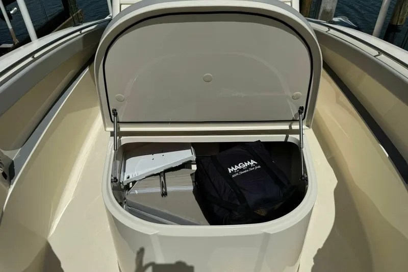 Slide: The Image of Open storage compartment on 2021 Scout 330 LXF boat, containing a Magma grill bag. - 14