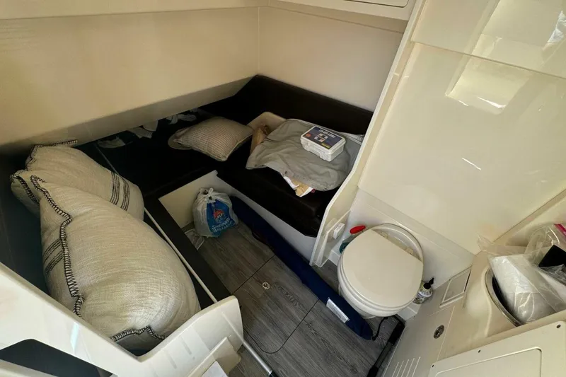 Slide: The Image of 2021 Scout 330 LXF cabin interior with bed, pillows, and compact toilet. - 16