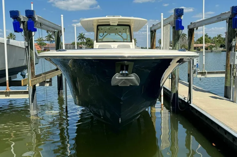 Slide: The Image of 2021 Scout 330 LXF boat docked in sunny marina, front view. - 3