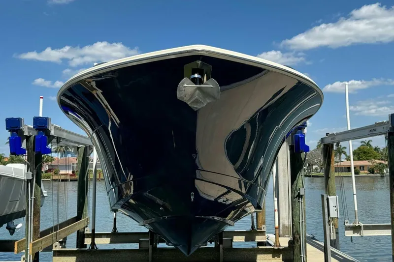 Slide: The Image of 2021 Scout 330 LXF boat on lift, reflecting sunlight, with blue sky background. - 4