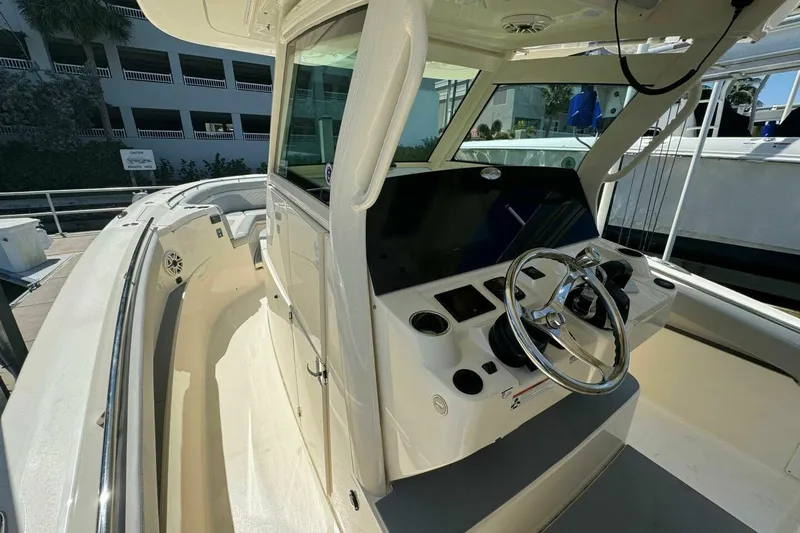 Slide: The Image of 2021 Scout 330 LXF boat helm with modern controls and steering wheel. - 9