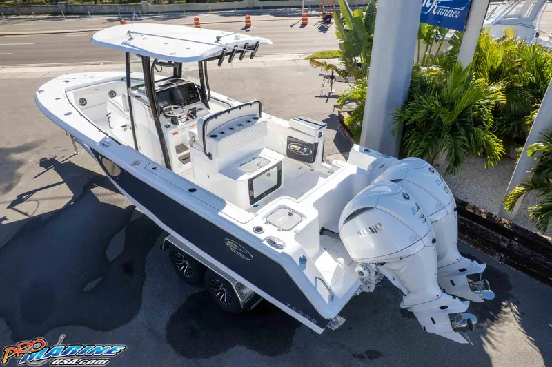 Slide: The Image of 2026 Sea Hunt Gamefish 27 Coffin Box boat with dual Yamaha engines, parked outdoors. - 16