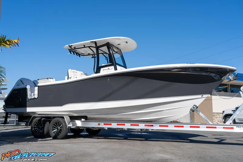 Slide: The Image of 2026 Sea Hunt Gamefish 27 Coffin Box boat on trailer, sleek design, sunny day. - 17