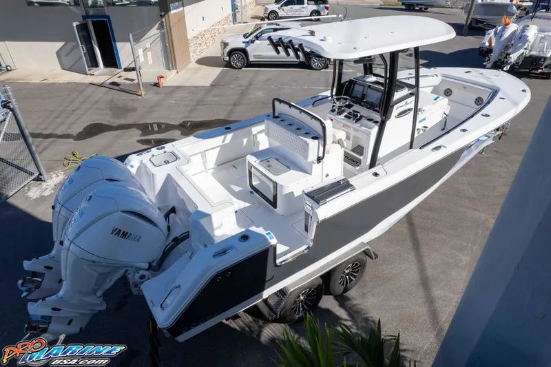 Slide: The Image of 2026 Sea Hunt Gamefish 27 Coffin Box boat with dual Yamaha engines, parked outdoors. - 26
