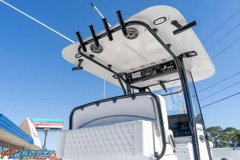 Slide: The Image of 2026 Sea Hunt Gamefish 27 Coffin Box boat, featuring rod holders and T-top, under clear blue sky. - 31