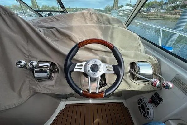 Slide: The Image of Steering wheel and controls of a 2003 Sea Ray 410 Sundancer boat. - 13