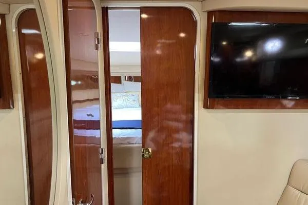 Slide: The Image of Interior of 2003 Sea Ray 410 Sundancer with wooden doors and mounted TV. - 20