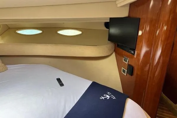 Slide: The Image of Interior of 2003 Sea Ray 410 Sundancer with bed, TV, and porthole windows. - 22