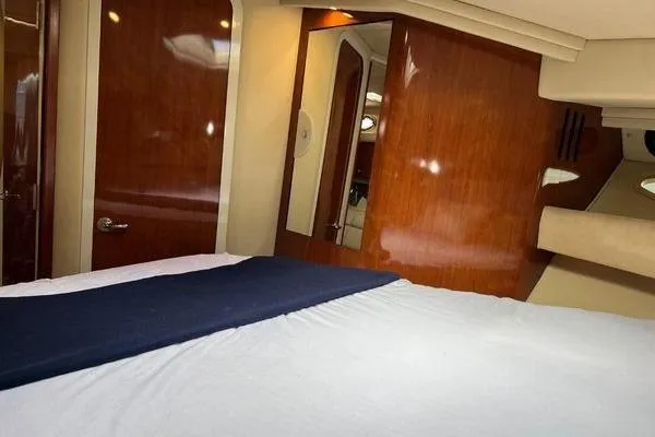 Slide: The Image of Interior cabin of 2003 Sea Ray 410 Sundancer with wood paneling and bed. - 23