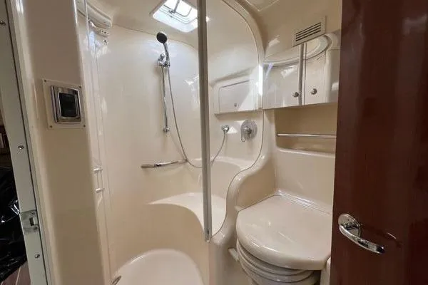 Slide: The Image of 2003 Sea Ray 410 Sundancer bathroom with shower, toilet, and storage cabinets. - 25