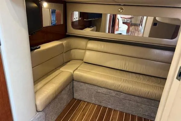 Slide: The Image of Luxurious interior of 2003 Sea Ray 410 Sundancer with beige leather seating and wood flooring. - 28