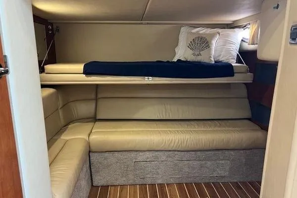 Slide: The Image of 2003 Sea Ray 410 Sundancer interior with beige seating and wooden flooring. - 29