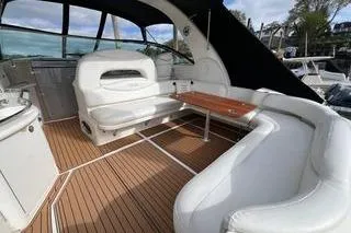 Slide: The Image of 2003 Sea Ray 410 Sundancer yacht interior with white seating and wooden table. - 3