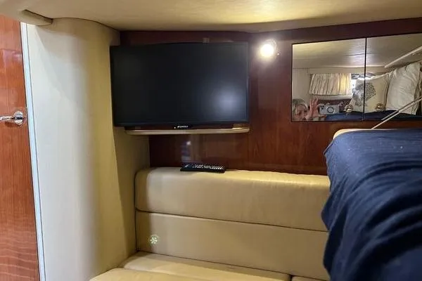 Slide: The Image of Interior of 2003 Sea Ray 410 Sundancer with TV, beige seating, and wood paneling. - 30