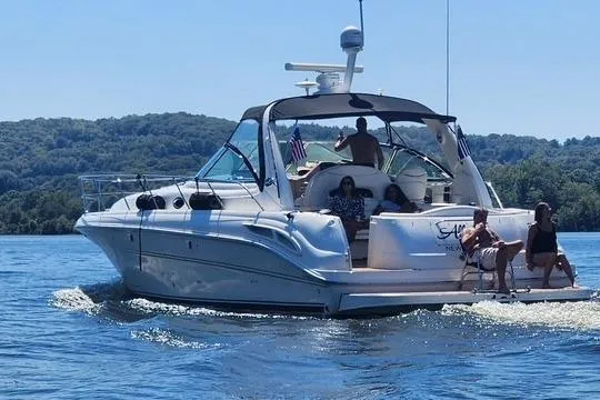 Slide: The Image of 2003 Sea Ray 410 Sundancer yacht cruising on a lake with passengers enjoying the sun. - 41