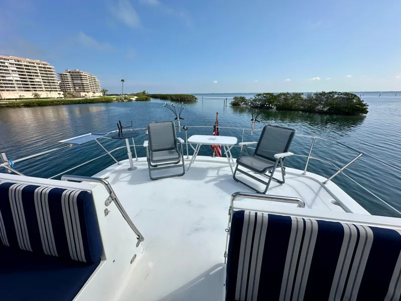 Slide: The Image of Deck view of 2002 Jefferson Marquessa 57 MY yacht with chairs and table, overlooking serene waters. - 12