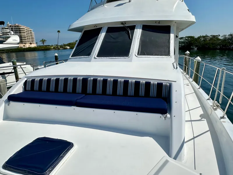 Slide: The Image of 2002 Jefferson Marquessa 57 MY yacht with striped seating, docked by calm waters. - 7