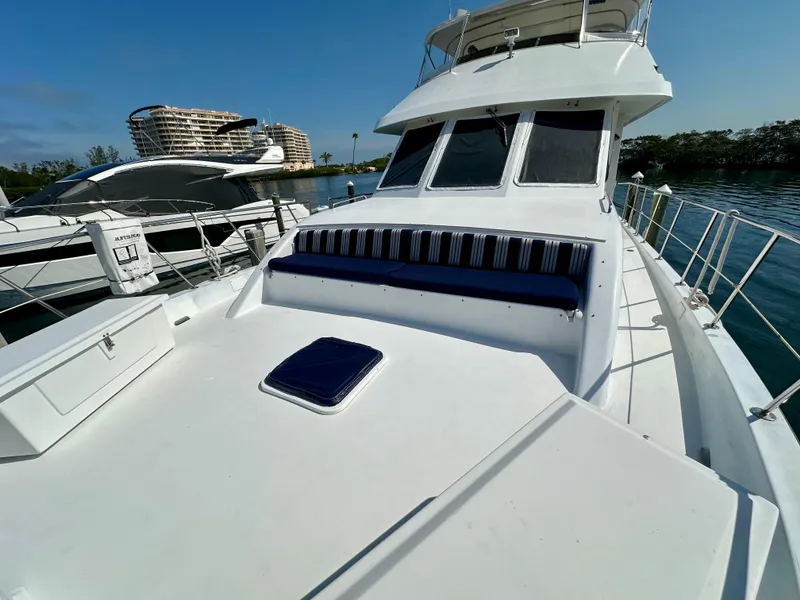 Slide: The Image of 2002 Jefferson Marquessa 57 MY yacht with spacious deck and seating, docked near modern buildings. - 8