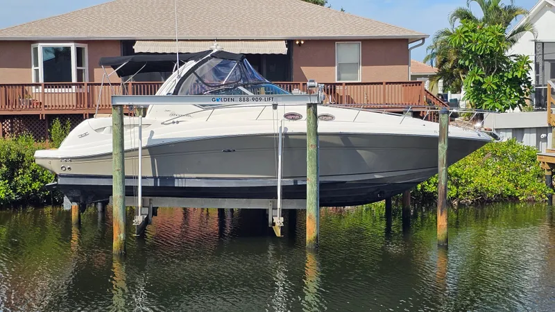 The Image of 2007 Sea Ray 340 Sundancer boat on lift near waterfront home. - 0