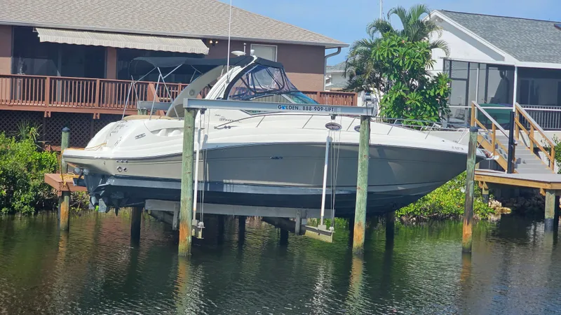 Slide: The Image of 2007 Sea Ray 340 Sundancer boat on lift near waterfront homes. - 1