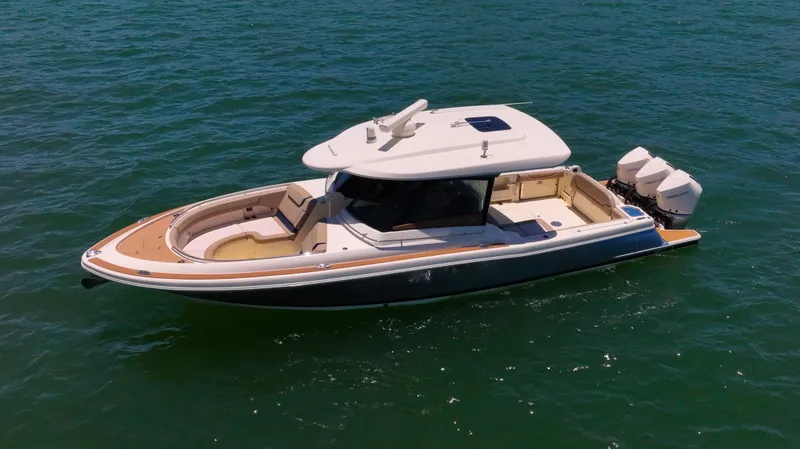 Slide: The Image of 2022 Chris-Craft Calypso 35 boat on open water, featuring sleek design and triple outboard engines. - 2