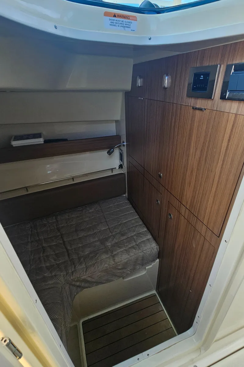 Slide: The Image of 2022 Chris-Craft Calypso 35 cabin interior with wood paneling and cozy bed. - 20