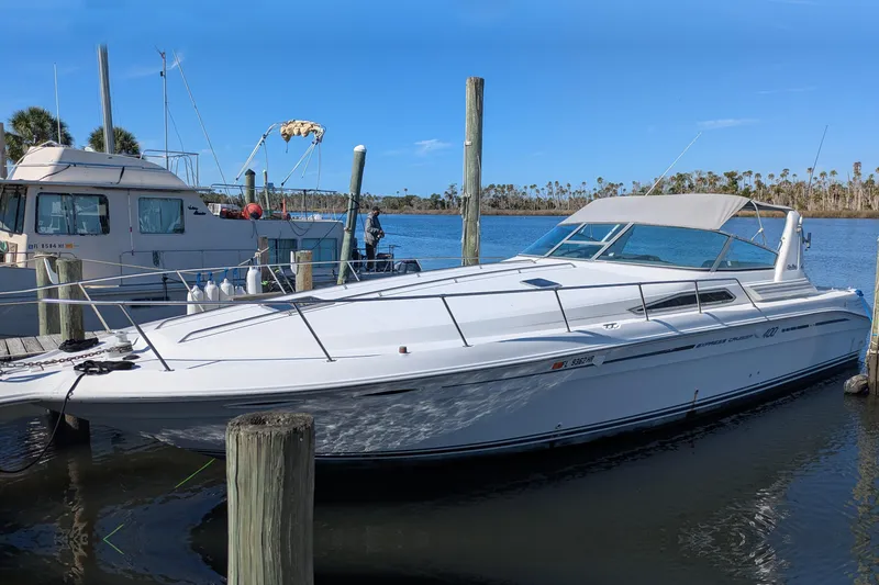 The Image of 1992 Sea Ray 400 Express Cruiser docked at marina under clear blue sky. - 0