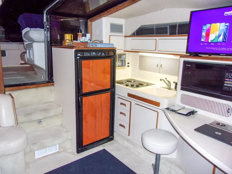 Slide: The Image of Interior of 1992 Sea Ray 400 Express Cruiser with kitchen and seating area. - 14