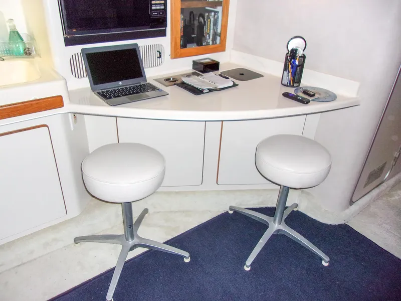 Slide: The Image of Interior of 1992 Sea Ray 400 Express Cruiser with desk, stools, and laptop. - 15