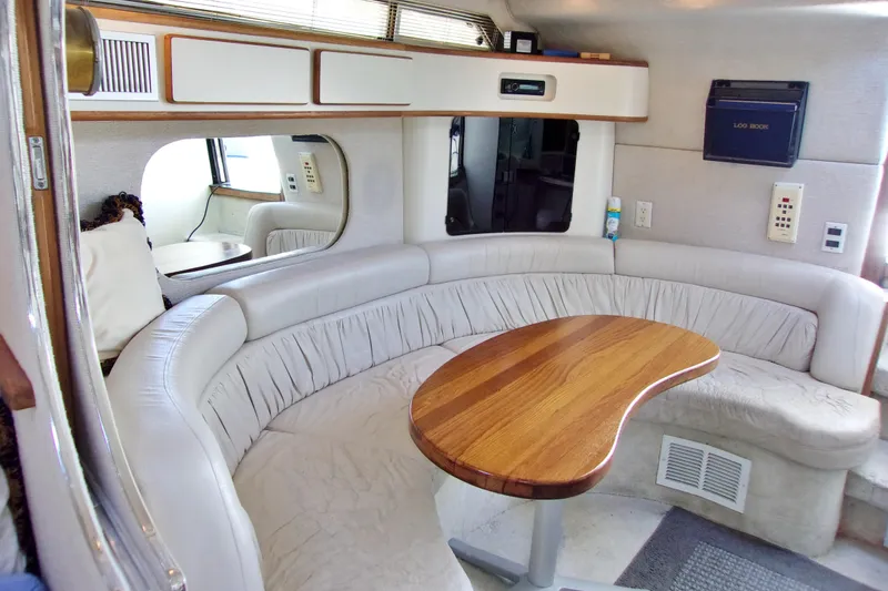 Slide: The Image of 1992 Sea Ray 400 Express Cruiser interior with curved seating and wooden table. - 18