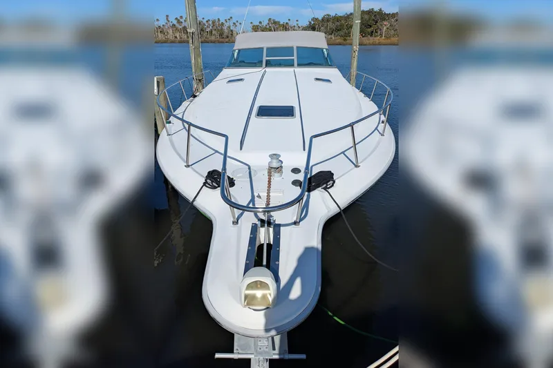 Slide: The Image of 1992 Sea Ray 400 Express Cruiser docked on calm water. - 2
