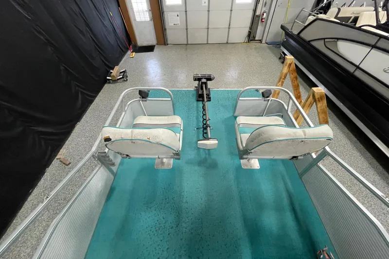 Slide: The Image of 1995 Weeres Fish 16 boat interior with two seats and teal carpet. - 11